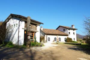 duży biały budynek z bramą przed nim w obiekcie Agriturismo Corte del Maso w mieście Bassano del Grappa