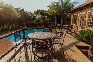 a patio with a table and chairs next to a pool at Boubou Bed and Breakfast in Rustenburg