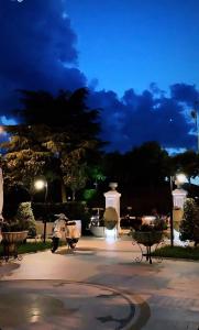 a park at night with a monument in the background at Univers Resort in Elbasan