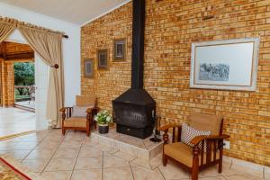 a brick wall with a stove in a living room at Boubou Bed and Breakfast in Rustenburg