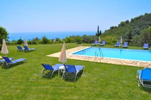a group of chairs and umbrellas next to a swimming pool at Galini Seaview Kontogialos in Pelekas