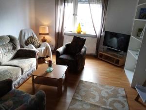 a living room with a couch and chairs and a television at Ferienwohnung Jacqueline in Erbach im Odenwald