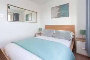 a bedroom with a bed and a mirror on the wall at Executive 3 Bed Apartment Aberdeen in Aberdeen