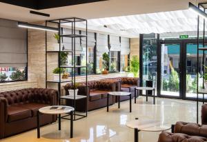 a waiting room with couches and tables and windows at BG Palace Hotel in Tbilisi City +60 photos