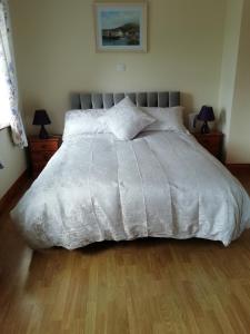 ein Bett mit einer weißen Bettdecke in einem Schlafzimmer in der Unterkunft Lisduvogue House in Ballina
