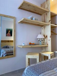 1 dormitorio con estanterías de madera, espejo y cama en Jardin de bougainvillier, en Sfax