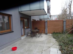 taras ze stołem i krzesłami obok budynku w obiekcie Apartament w centrum, garaż i jakuzzi w cenie we Wrocławiu +2 zdjęcia