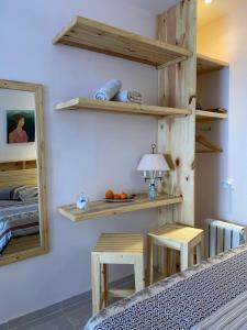 ein Schlafzimmer mit Holzregalen, einem Bett und 2 Tischen in der Unterkunft Jardin de bougainvillier in Sfax