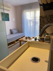 une cuisine avec un évier et un canapé dans une chambre dans l'établissement Jardin de bougainvillier, à Sfax