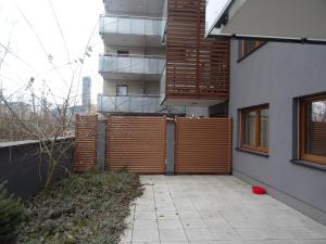 a building with a wooden fence next to a sidewalk at Apartament w centrum, garaż i jakuzzi w cenie in Wrocław