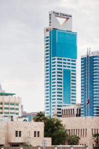 ein hohes Gebäude mit einem Schild darüber in der Unterkunft The Domain Bahrain Hotel and Spa - Adults Friendly 16 Years Plus in Manama