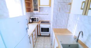 a small kitchen with a sink and a stove at Apartament, Kwatera Prywatna - SŁONECZNA PLAŻA dwupokojowe balkon wifi 20 min spacerkiem od plaży in Gdańsk