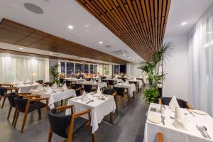 a dining room with white tables and chairs at Tasia Maris Beach Hotel - Adults Only in Ayia Napa