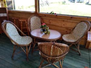 a table and four chairs and a table with flowers at Vysoké Tatry Gerlaška in Tatranská Polianka