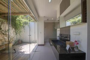 a kitchen with a sink and a glass wall at Pousada do Toque in São Miguel dos Milagres