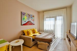 ein kleines Wohnzimmer mit einem Sofa und einem TV in der Unterkunft NEAPOLITAN SKYSCRAPER APARTMENT in Neapel
