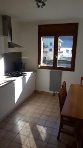 cocina con mesa, fogones y ventana en Appartement au pied des 3 Vallées, en Moutiers