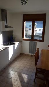 a kitchen with a table and a stove and a window at Appartement au pied des 3 Vallées in Moutiers