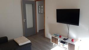 a living room with a flat screen tv on a wall at Appartement au pied des 3 Vallées in Moutiers