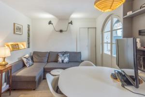 a living room with a couch and a table at Appartement Odyssée - Welkeys in Megève