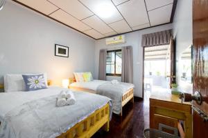 Giường trong phòng chung tại Bluebell House Hatyai - Cosy 3 bedrooms for 10 pax - 9 mins drive to Lee Grd