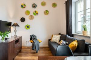 a living room with a couch and plates on the wall at Solny Square Aparthotel in Wrocław