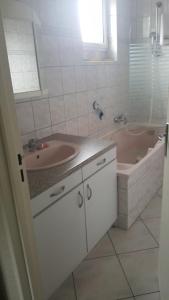 a bathroom with a tub and a sink and a bath tub at Le repaire du deux roues in Saint-Sauveur