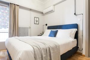 a bedroom with a large bed with a blue headboard at Deluxe & Stylish 2BD Apartment in Pangrati by UPSTREET in Athens