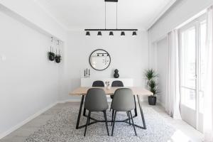 a dining room with a table and chairs and a clock at Deluxe & Stylish 2BD Apartment in Pangrati by UPSTREET in Athens