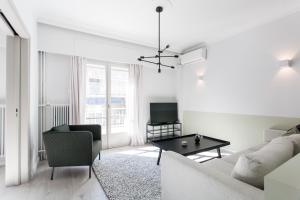 a living room with a couch and a table at Deluxe & Stylish 2BD Apartment in Pangrati by UPSTREET in Athens