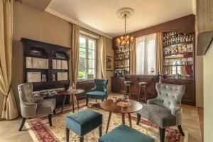 a living room with chairs and tables and a piano at The Lake Como Villa in Menaggio