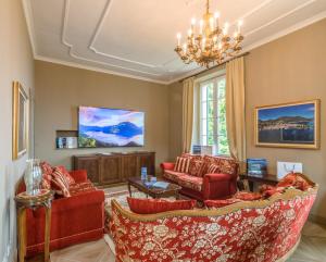 a living room with red furniture and a chandelier at The Lake Como Villa in Menaggio