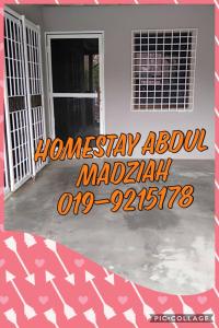 una puerta de entrada de una casa con la madril del álbum wordsiversary en Homestay Abdul, en Kampung Banggul Gucil