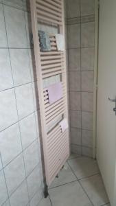 a bathroom with a towel rack in a shower at Le repaire du deux roues in Saint-Sauveur