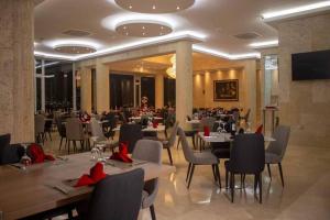 un restaurante con mesas y sillas con arcos rojos en Hotel Súper Estrellas, en Barrancabermeja