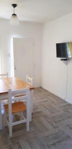 a dining room with a table and a tv at La Soñada - cabañas in Cruz del Eje