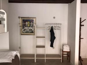 a white bedroom with a shelf and a bed at La Coccola in Venice