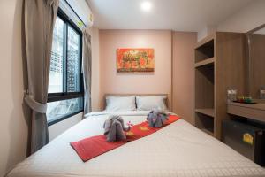 um quarto com uma cama com dois bichos de peluche em The Moon Night Hotel em Bangkok