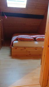 Cama pequeña en habitación de madera con ventana en Apartment in old farmhouse en Bockholtz