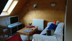 Apartment in old farmhouse في Bockholtz: غرفة معيشة مع أريكة بيضاء وطاولة