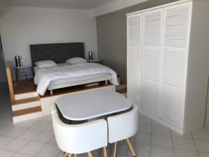 カンヌにあるLes Princesの白いベッドルーム(ベッド1台、白い椅子付)