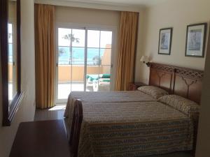 1 dormitorio con cama y vistas al océano en Apartamentos Nerja Bahia, en Nerja
