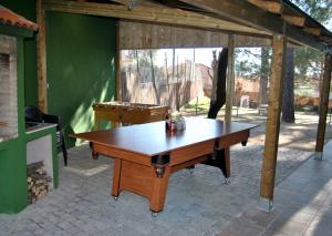 Complejo Casas Rurales MANSIONES Y VILLAS DELUXE في Collado Mediano: طاولة خشبية كبيرة في جناح في ساحة