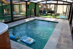 - une piscine avec des nouilles dans l'eau dans l'établissement Complejo Casas Rurales MANSIONES Y VILLAS DELUXE, à Collado Mediano