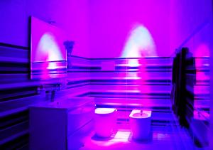 B&b Vittorio Emanuele II في فوجيا: حمام به أضواء وردية وأرجوانية ومرحاض