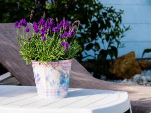 un jarrón lleno de flores púrpuras sentado en una mesa en Casa Olina en Bahia de Casares