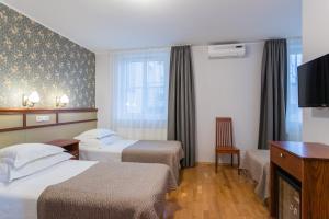 a hotel room with two beds and a flat screen tv at Hotel Villa Wesset in Pärnu +58 photos
