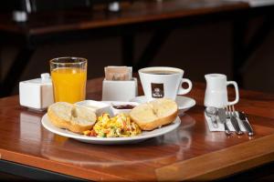 a breakfast plate of eggs and toast and a cup of coffee at Central Bed & Breakfast in Iquitos