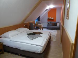 a bedroom with a bed and a living room at Landhotel Auerose Garni in Neu Kosenow