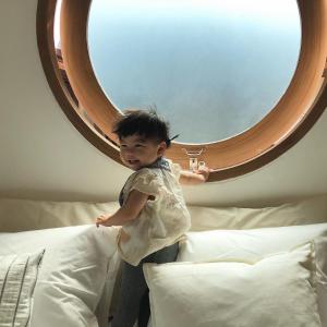 uma criança em pé numa cama em frente a um espelho em Marlowe-Tony's home em Bangkok